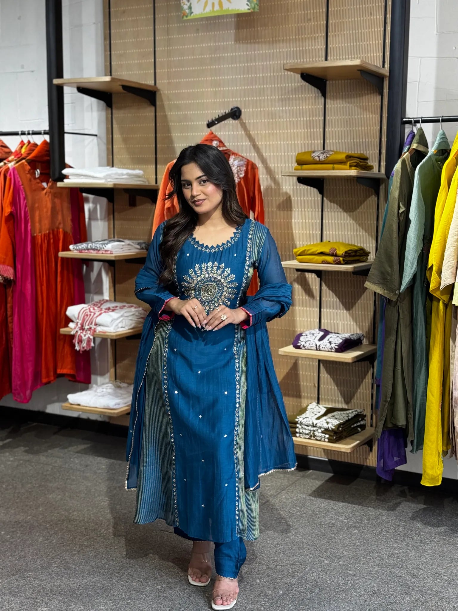 Petrol-blue chanderi kurta with a gold medallion embroidered at the yoke, dupatta over one shoulder in the boutique.