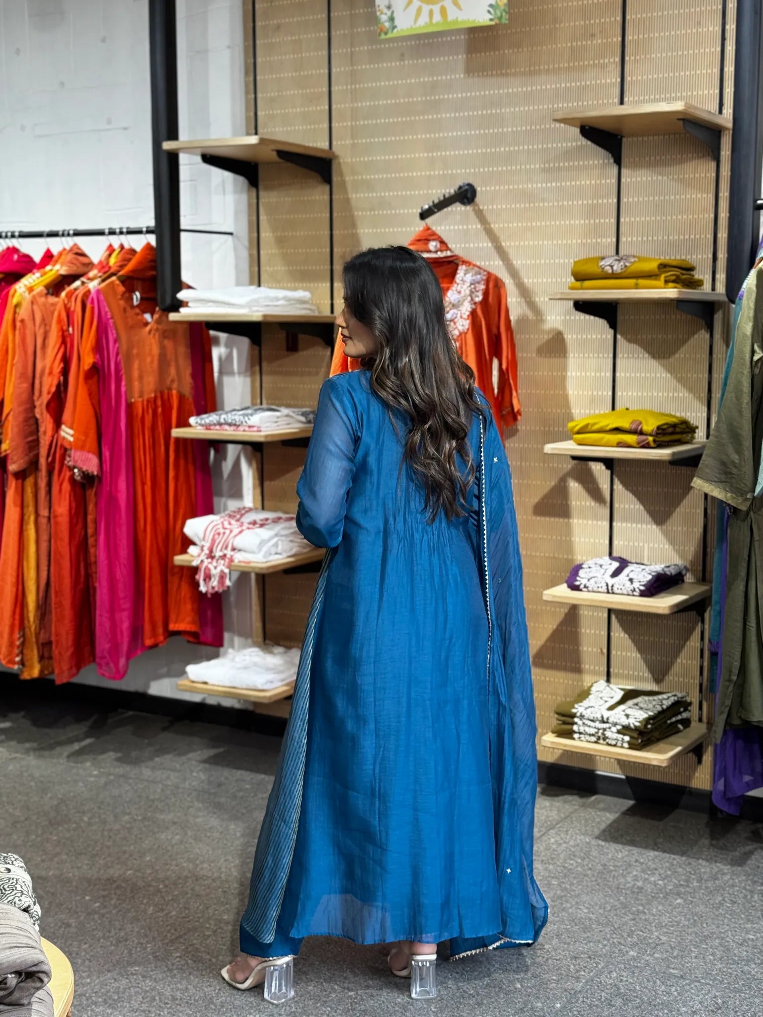 Rear three-quarter view of the blue kurta set, the dupatta hanging straight down the back over the flared hem.