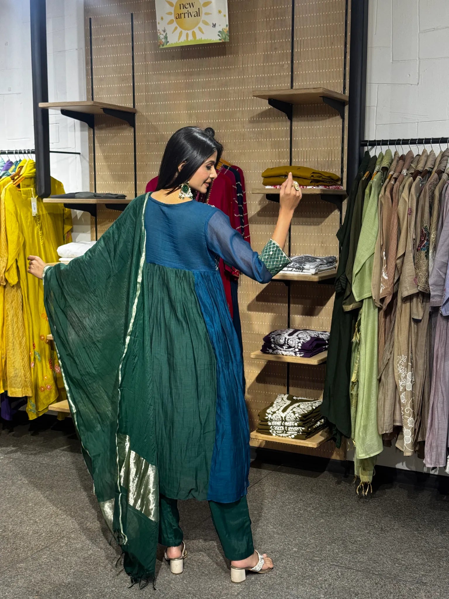 Back view of a teal and green mul chanderi A-line kurta pant set, the deep green dupatta spread wide to show its zari border.