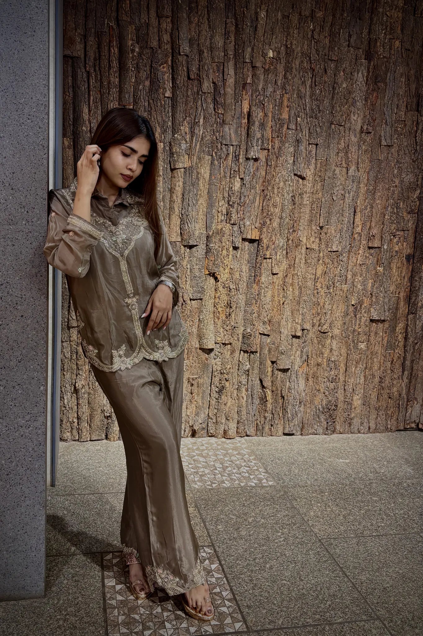 Beige chinnon co-ord set with a lace-edged shirt-collar top and wide plazo, the taupe satin catching light against a timber wall.