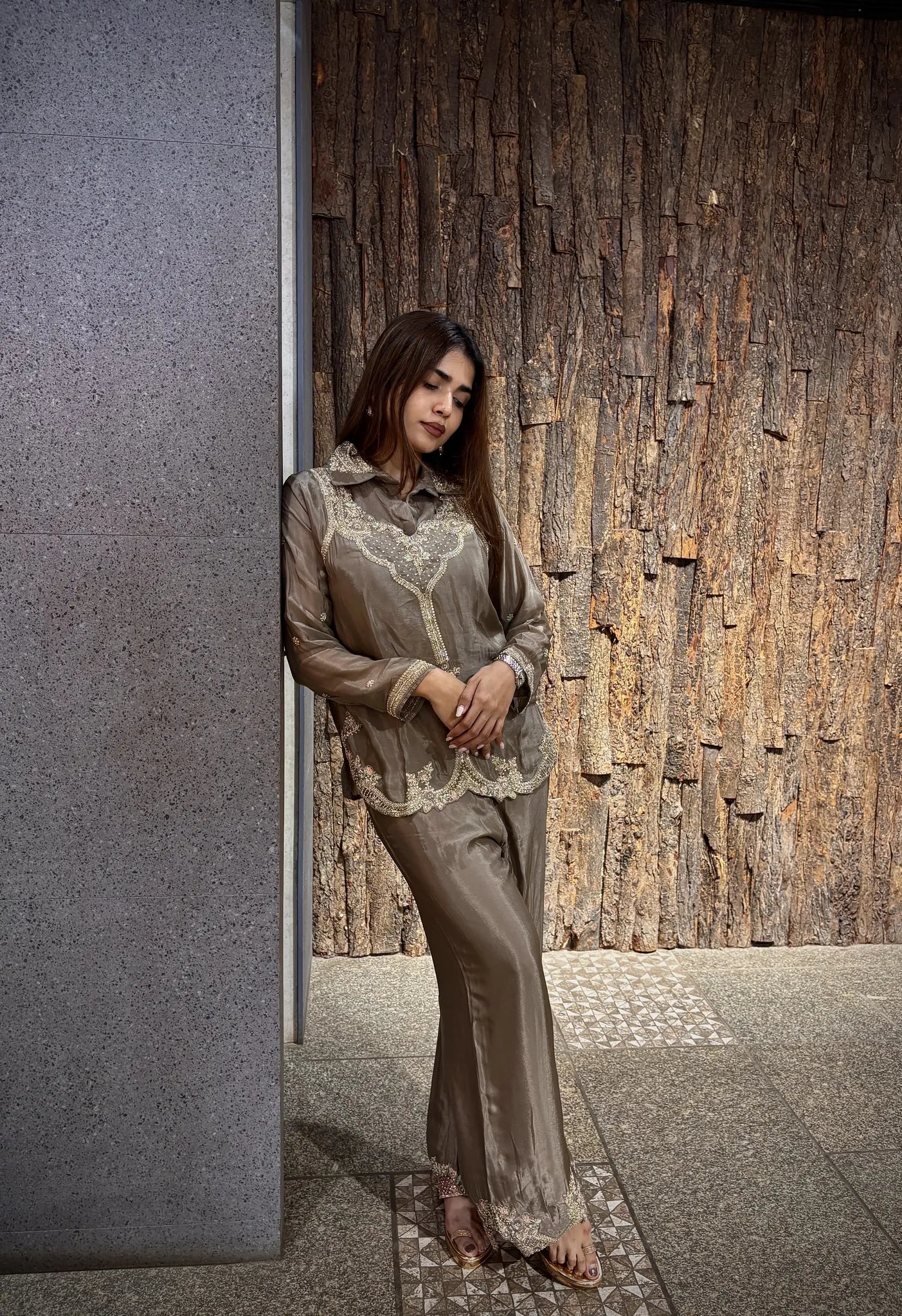 Side view of the beige chinnon co-ord, the shirt collar open at the neck and the plazo falling straight to a lace hem.
