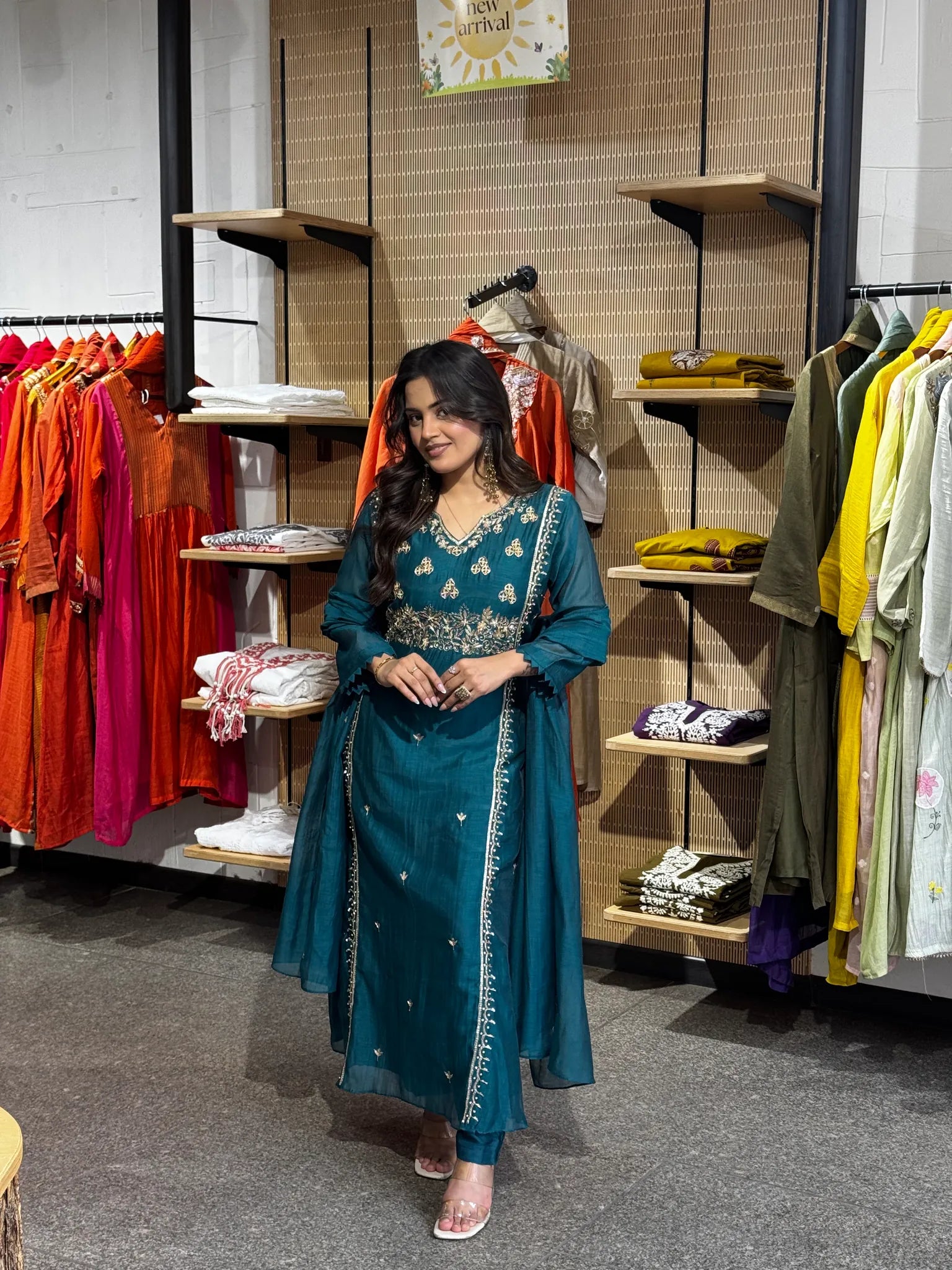 Teal-green chanderi kurta with a gold-embroidered yoke, sheer dupatta edged in gold falling to the floor beside her.