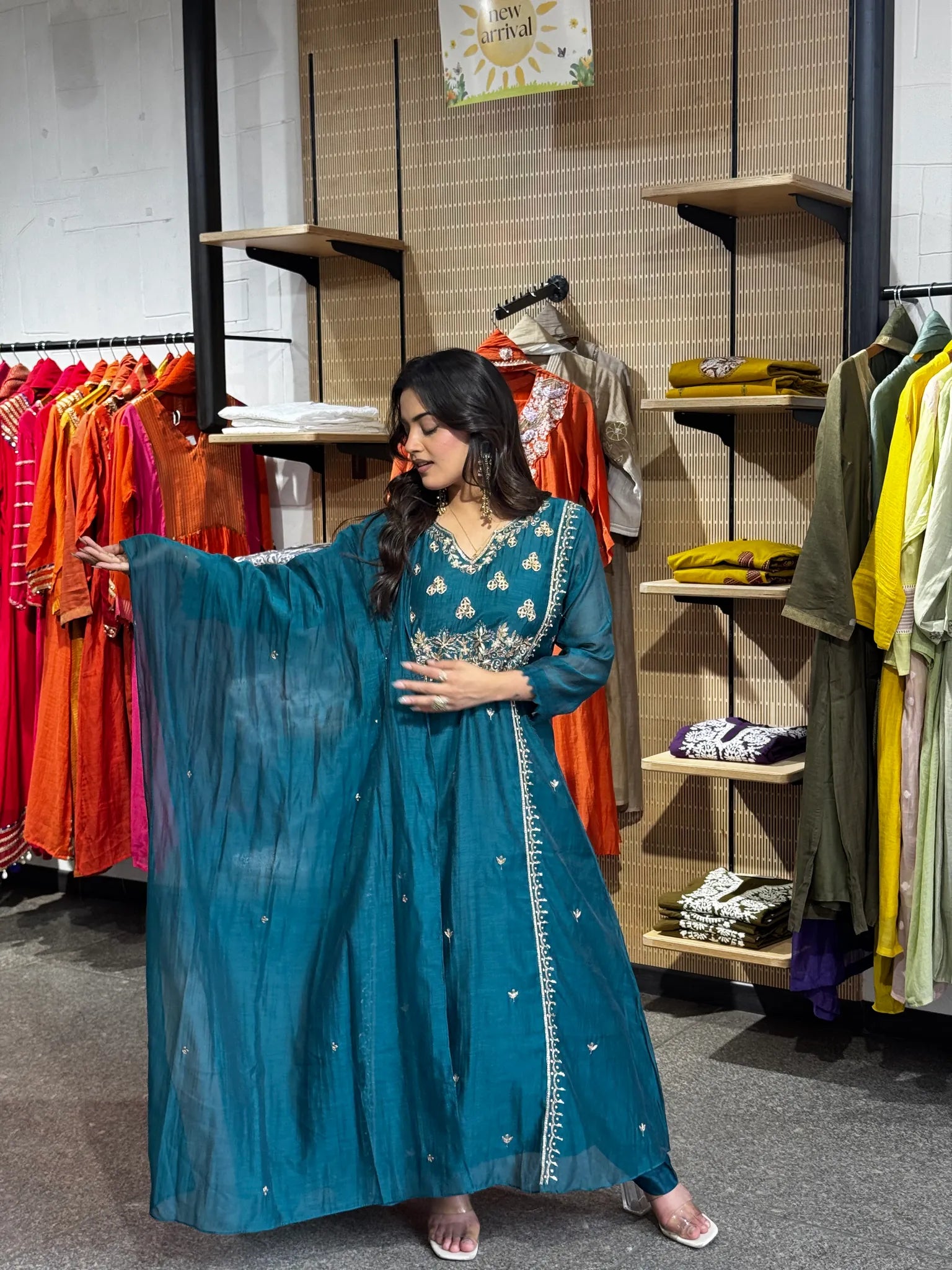 The teal dupatta held open across the frame, its gold border framing the embroidered yoke of the kurta beneath.