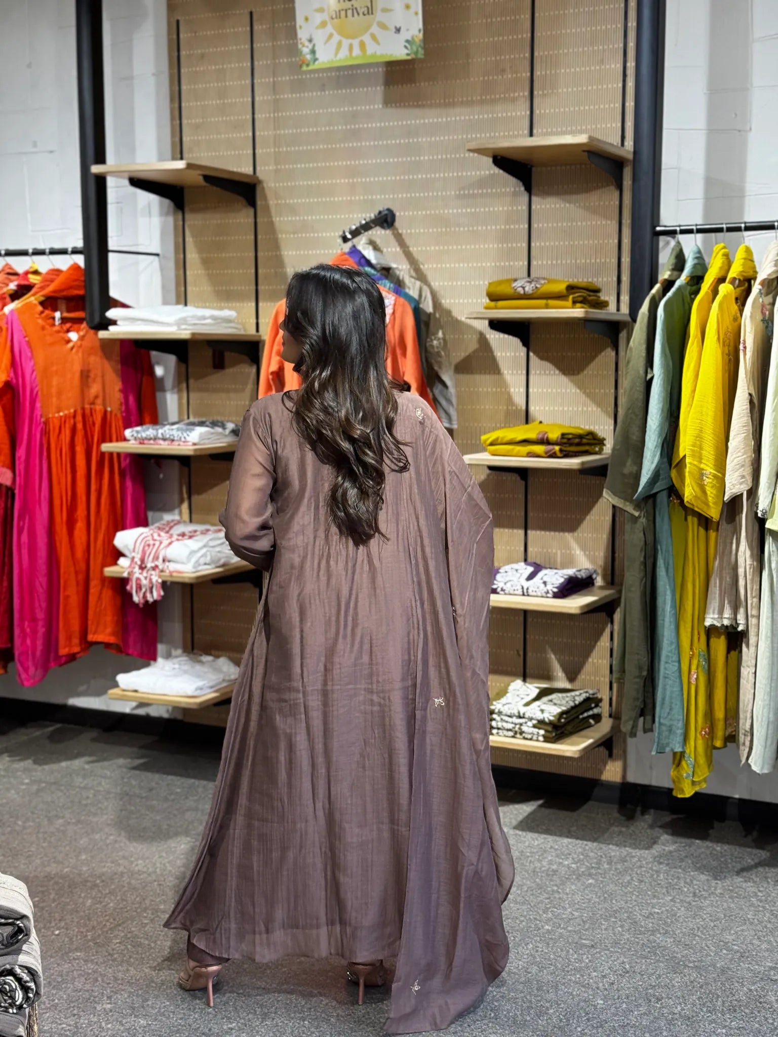 Side-on in the dusty mauve set, one hand on the hip and the dupatta running the full length of the flowing kurta.