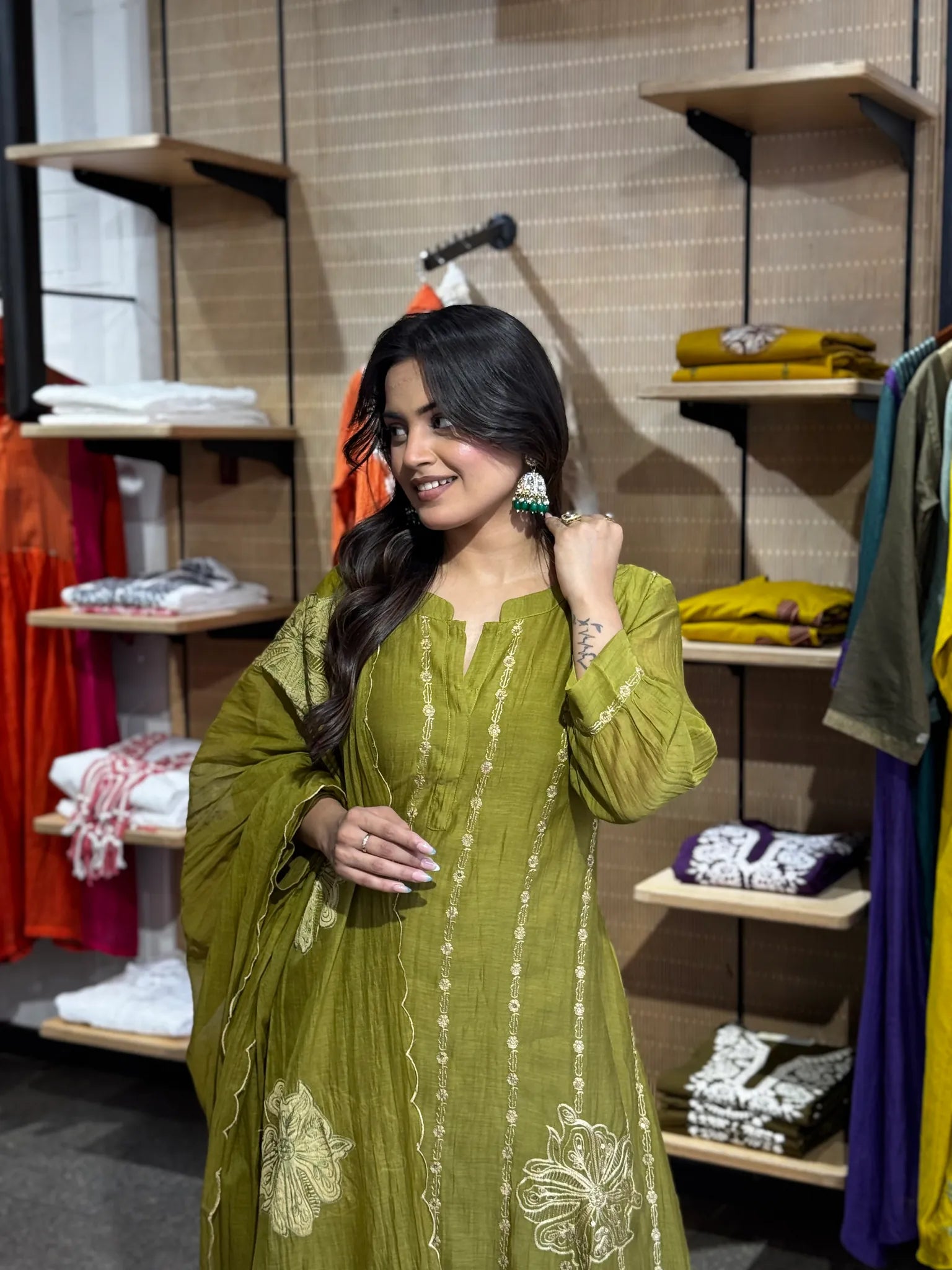 Green jhumka earrings worn with the mehendi chanderi kurta, its neckline finished in fine ivory thread detailing.