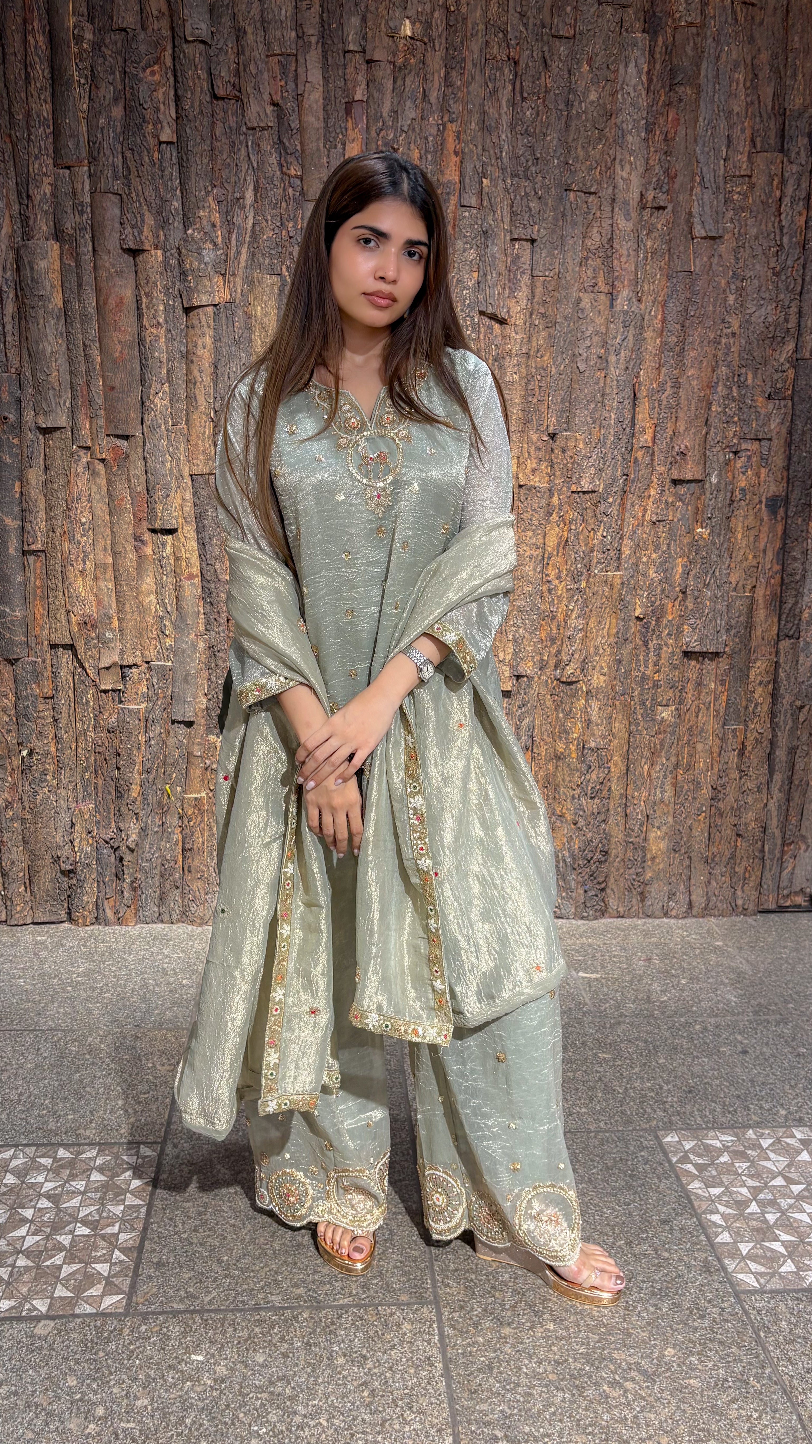 Pista green tissue kurta with gold zari embroidery at the neck and hem, worn over a wide plazo with a matching dupatta.