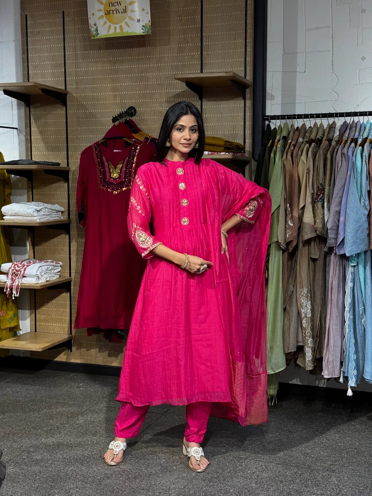A woman modeling a rani pink mul chanderi A-line kurta pant set, one hand on her hip, with the dupatta over one shoulder.