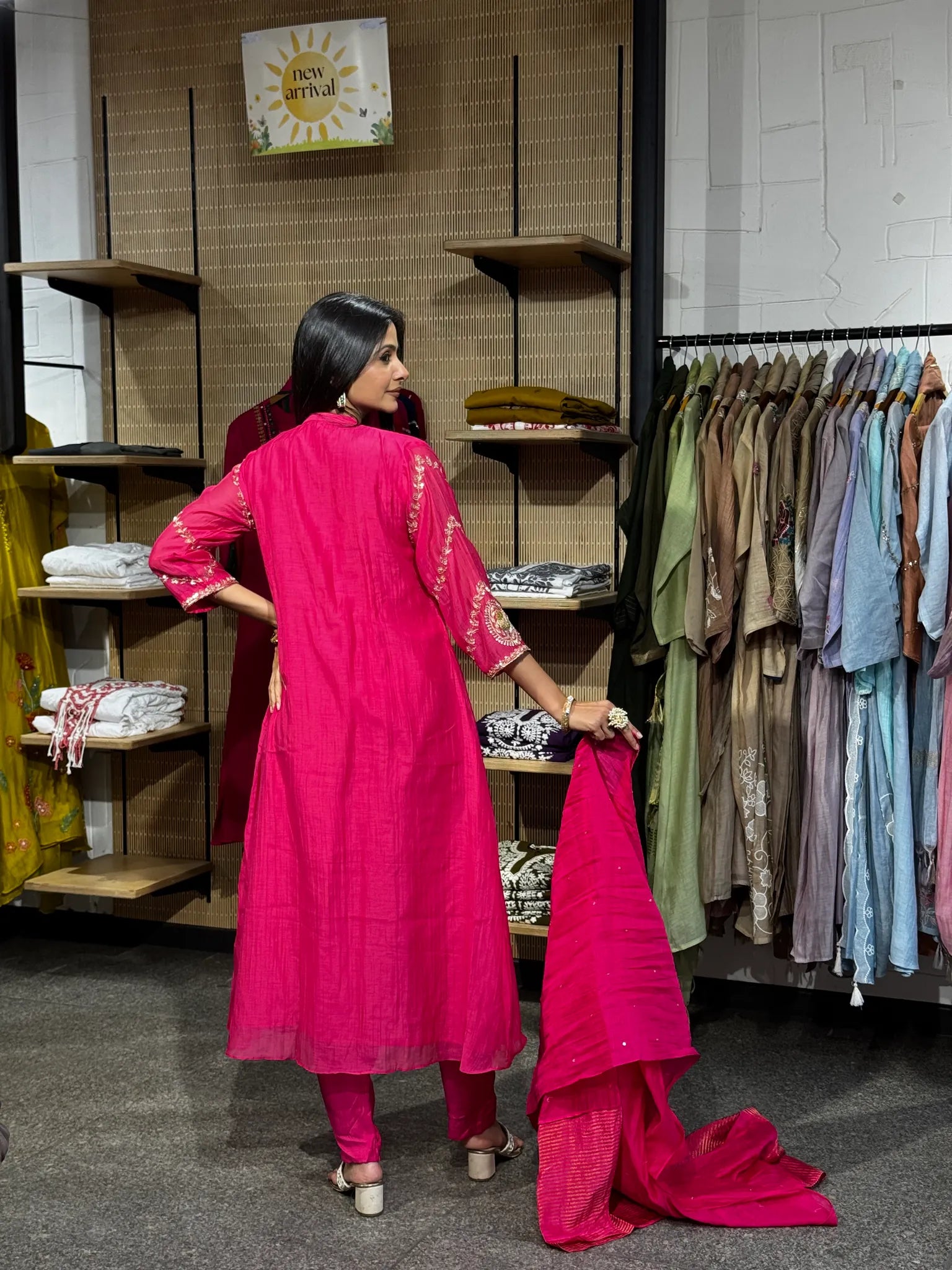 Back view of a rani pink mul chanderi A-line kurta pant set, the model holding the dupatta open to show its full length.