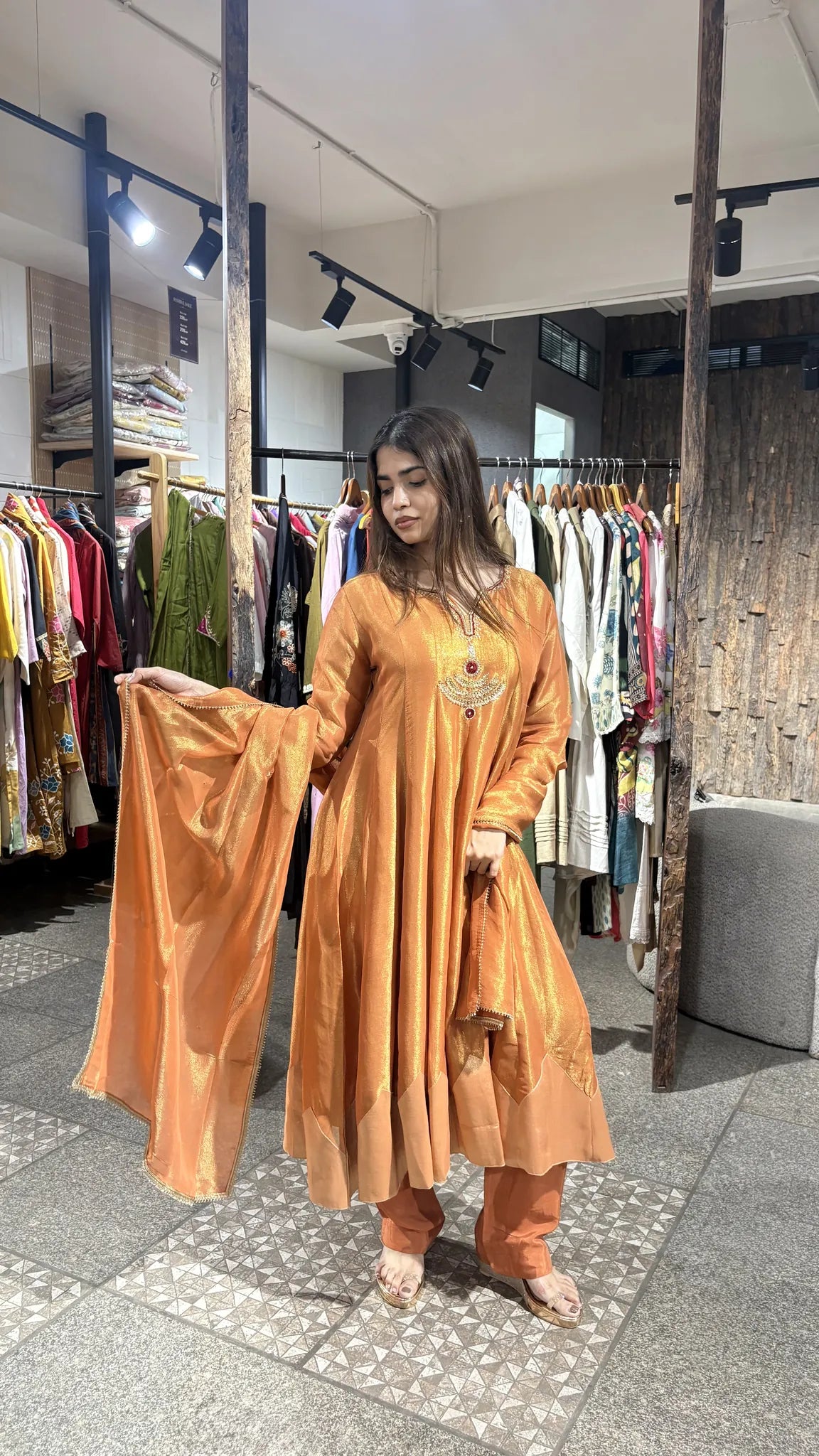 The rust orange tissue dupatta held wide open, showing its sheen and the embroidered yoke of the A-line kurta.