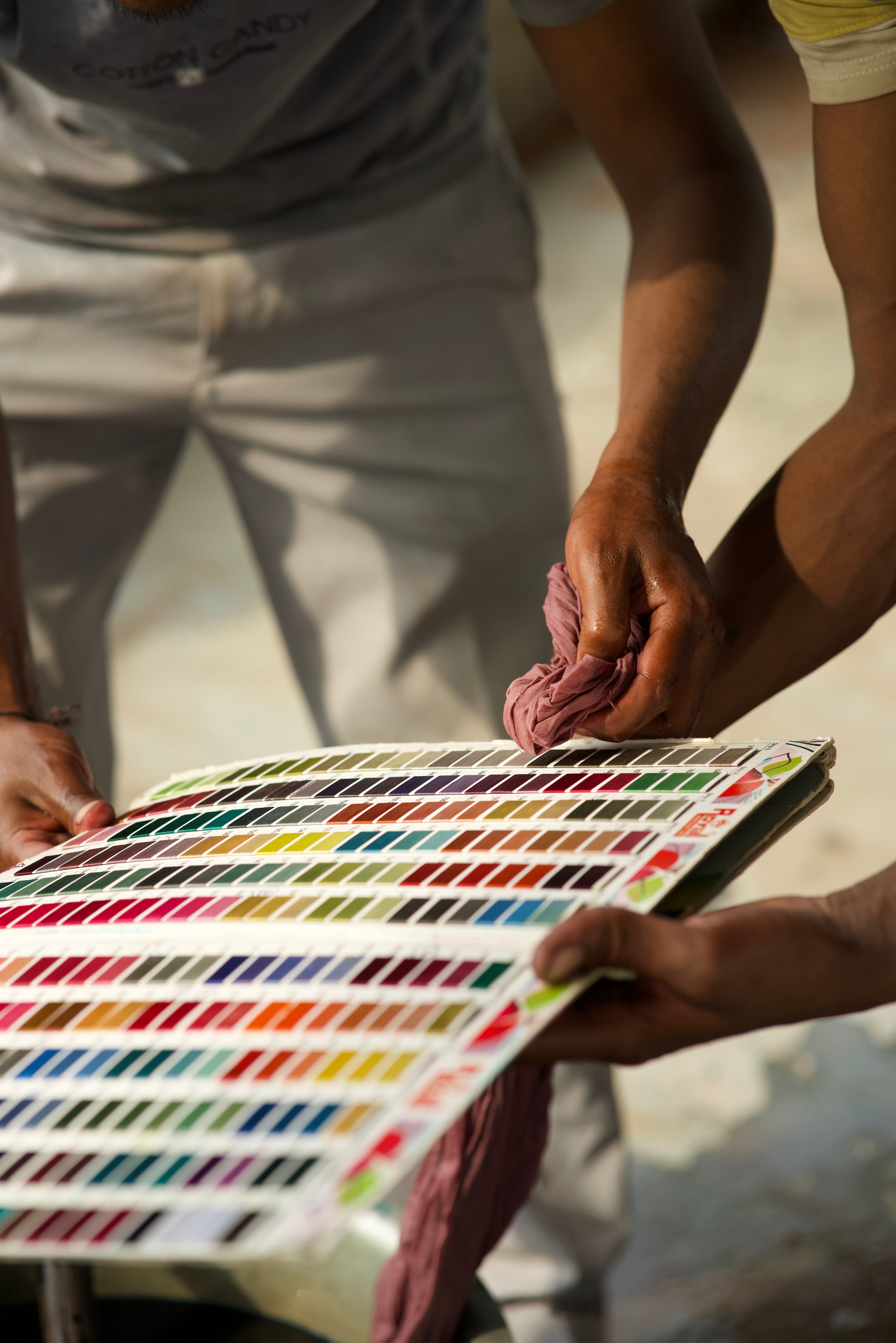 Person holding a color swatch chart outdoors