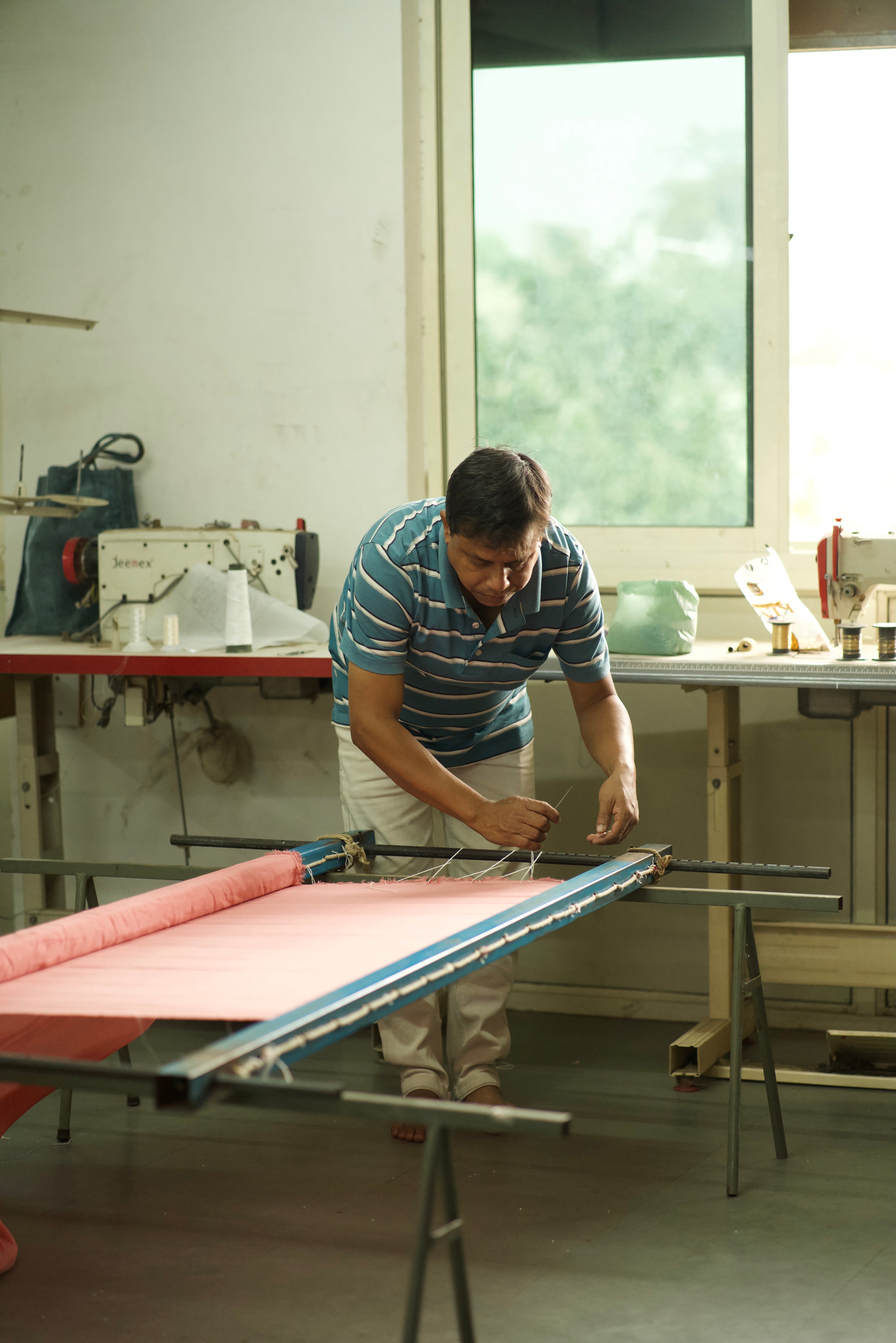 Man working on a large flat surface in a workshop.