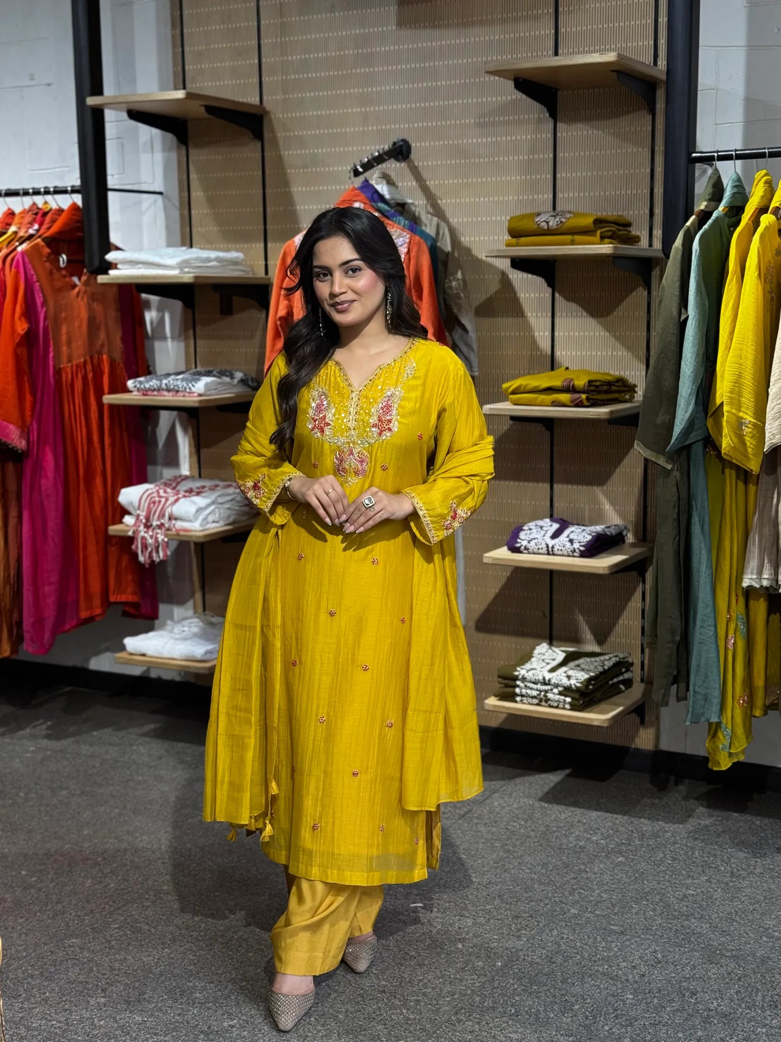 Mustard-yellow russian silk kurta with a pink and ivory embroidered yoke, matching palazzo and dupatta, in the boutique.